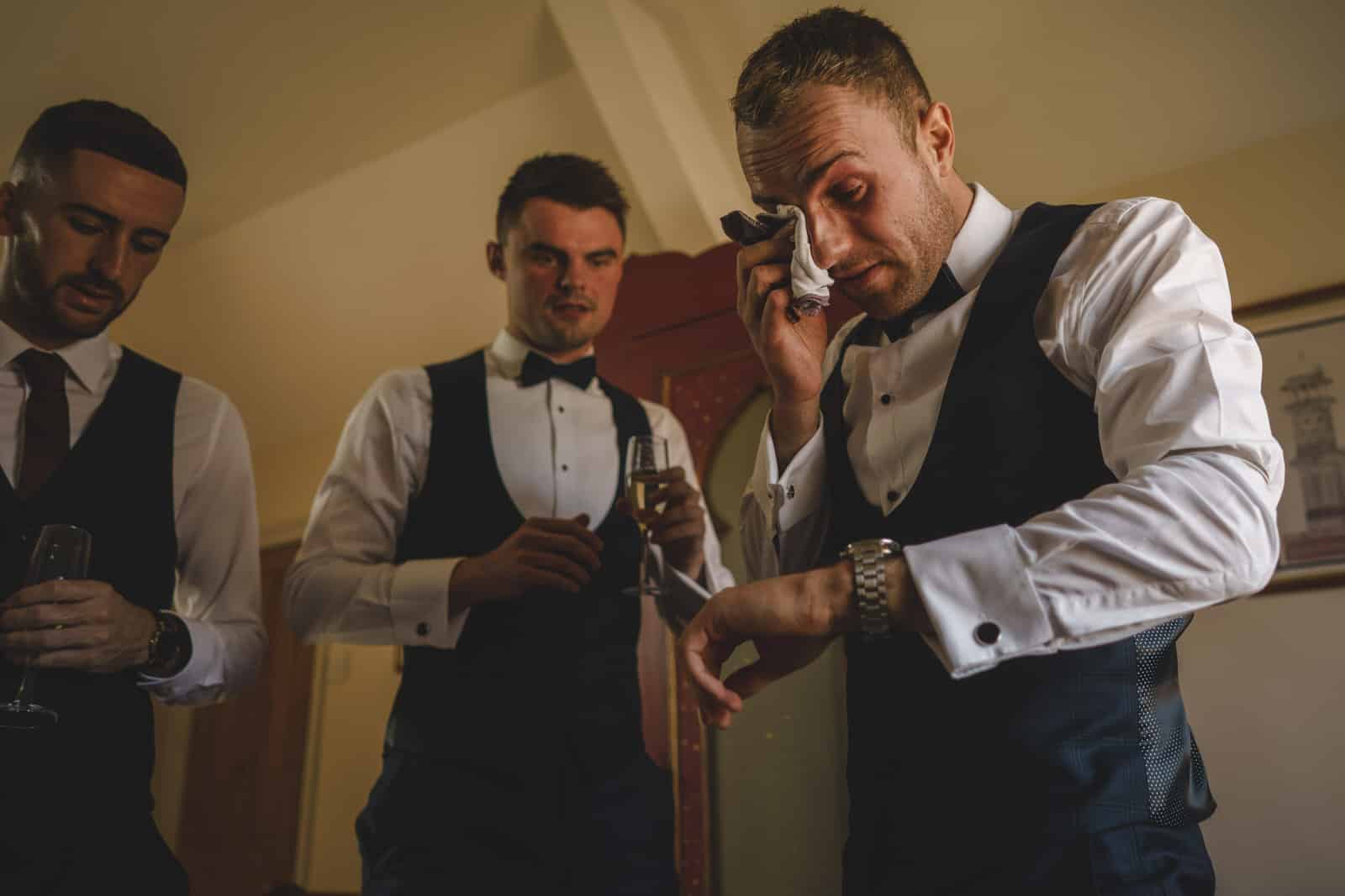 The groom is overcome with emotion as he looks down upon his gift from his beautiful bride